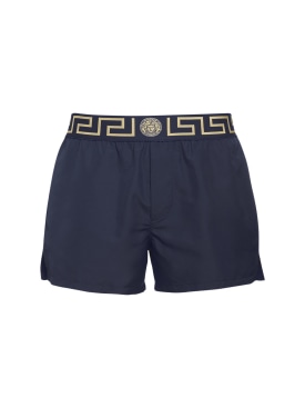 Versace: Monogram waistband tech swim shorts - Royal/Gold - men_0 | Luisa Via Roma