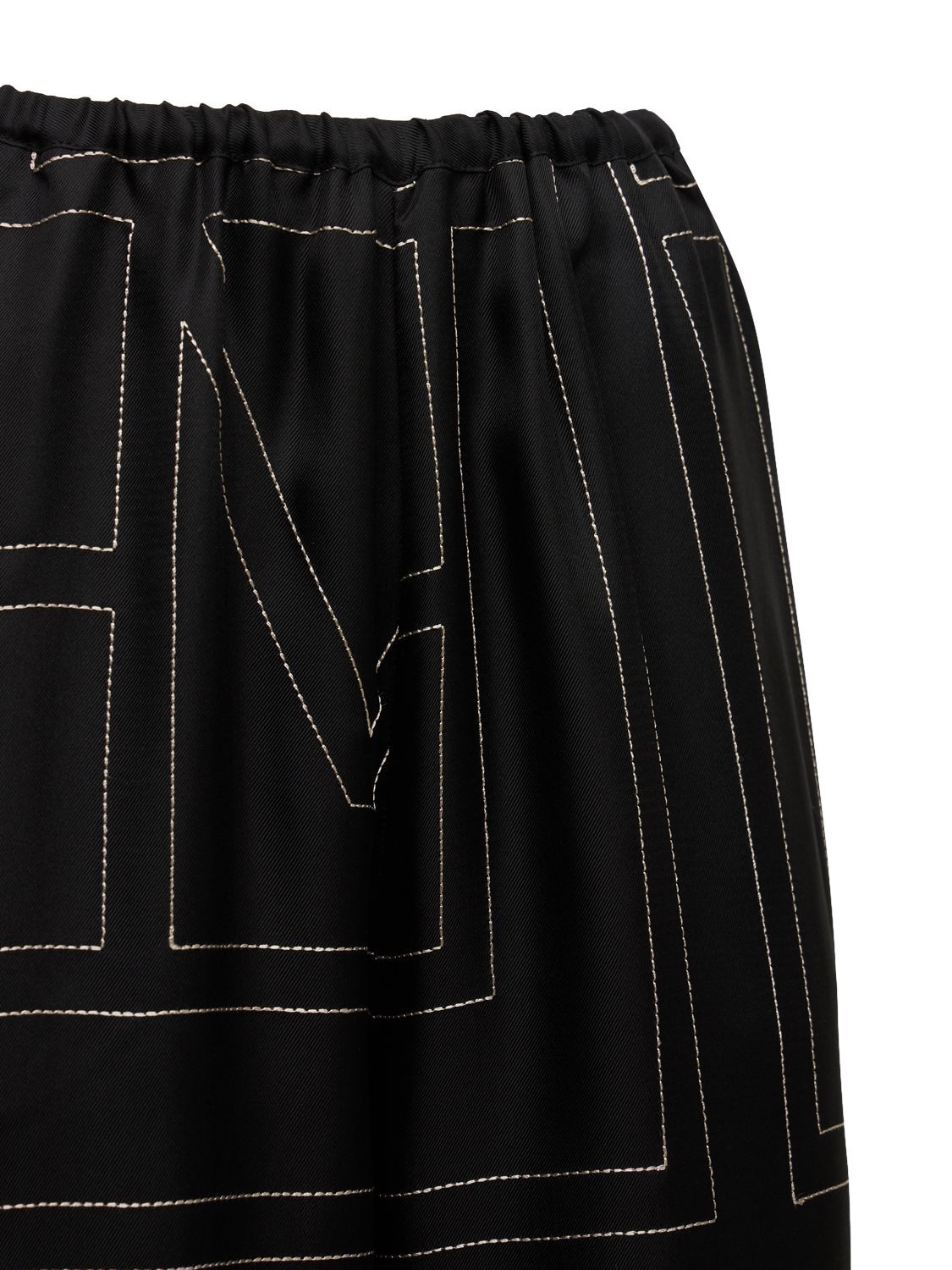 Shop Totême Monogram Embroidered Silk Pants In Black